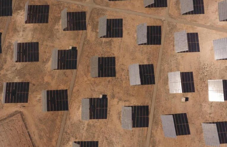 A large-scale solar photovoltaic installation in a Middle Eastern desert region, featuring rows of monocrystalline solar panels mounted on fixed-tilt structures under intense direct sunlight. The image captures the typical environmental conditions affecting panel performance in arid climates — including high ambient temperatures, dry air, and clear skies — which contribute to elevated panel surface heat. This visual representation is directly related to the thermal power coefficient, a critical performance metric that defines how panel efficiency decreases as temperature rises. As seen here, the solar modules are exposed to operating conditions where the thermal coefficient plays a significant role in determining energy output, especially during peak solar hours. The harsh climate and elevated heat index in this region underline the importance of selecting solar panels with optimized thermal characteristics to minimize efficiency losses. This context highlights the relevance of thermal management strategies such as passive cooling design, panel spacing, and high-efficiency cell technologies in large-scale solar deployments across the Middle East. The image reinforces the article's focus on how solar PV systems are affected by thermal performance variables in hot climates, making it essential for developers and EPCF contractors to integrate temperature coefficients into their design and procurement decisions.