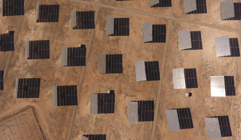 A large-scale solar photovoltaic installation in a Middle Eastern desert region, featuring rows of monocrystalline solar panels mounted on fixed-tilt structures under intense direct sunlight. The image captures the typical environmental conditions affecting panel performance in arid climates — including high ambient temperatures, dry air, and clear skies — which contribute to elevated panel surface heat. This visual representation is directly related to the thermal power coefficient, a critical performance metric that defines how panel efficiency decreases as temperature rises. As seen here, the solar modules are exposed to operating conditions where the thermal coefficient plays a significant role in determining energy output, especially during peak solar hours. The harsh climate and elevated heat index in this region underline the importance of selecting solar panels with optimized thermal characteristics to minimize efficiency losses. This context highlights the relevance of thermal management strategies such as passive cooling design, panel spacing, and high-efficiency cell technologies in large-scale solar deployments across the Middle East. The image reinforces the article's focus on how solar PV systems are affected by thermal performance variables in hot climates, making it essential for developers and EPCF contractors to integrate temperature coefficients into their design and procurement decisions.