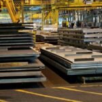 Steelbridge Export international trading team overseeing metal shipment at a global port with stacked containers and steel coils.