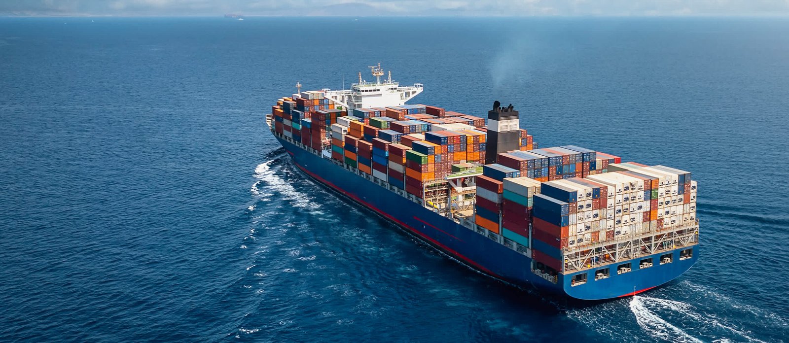 A cargo ship loaded with raw materials arriving at an international port—Steelbridge Export facilitating global trade.
