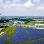 Large-scale industrial solar panel system on a factory rooftop in a Middle Eastern desert, optimized for thermal control and high-efficiency output.