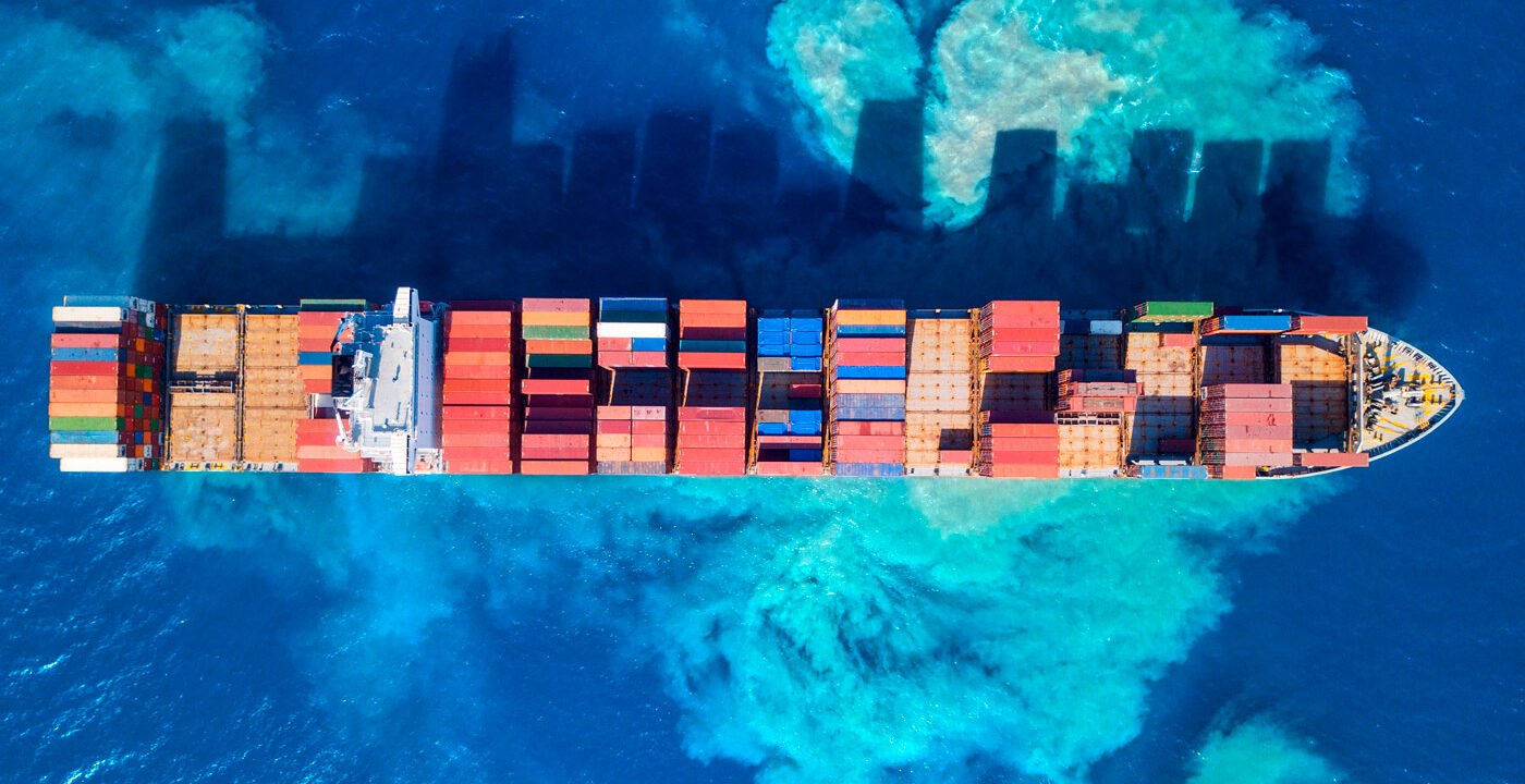 A cargo ship loaded with raw materials arriving at an international port—Steelbridge Export facilitating global trade.