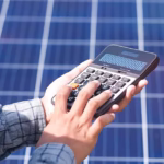 Investor reviewing renewable energy portfolio with solar panels, wind turbines, and clean energy infrastructure in the background.