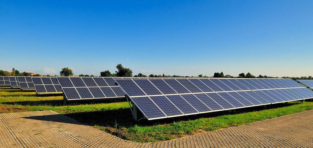 Solar panels and fossil fuel power plants comparison highlighting cost differences in 2025.